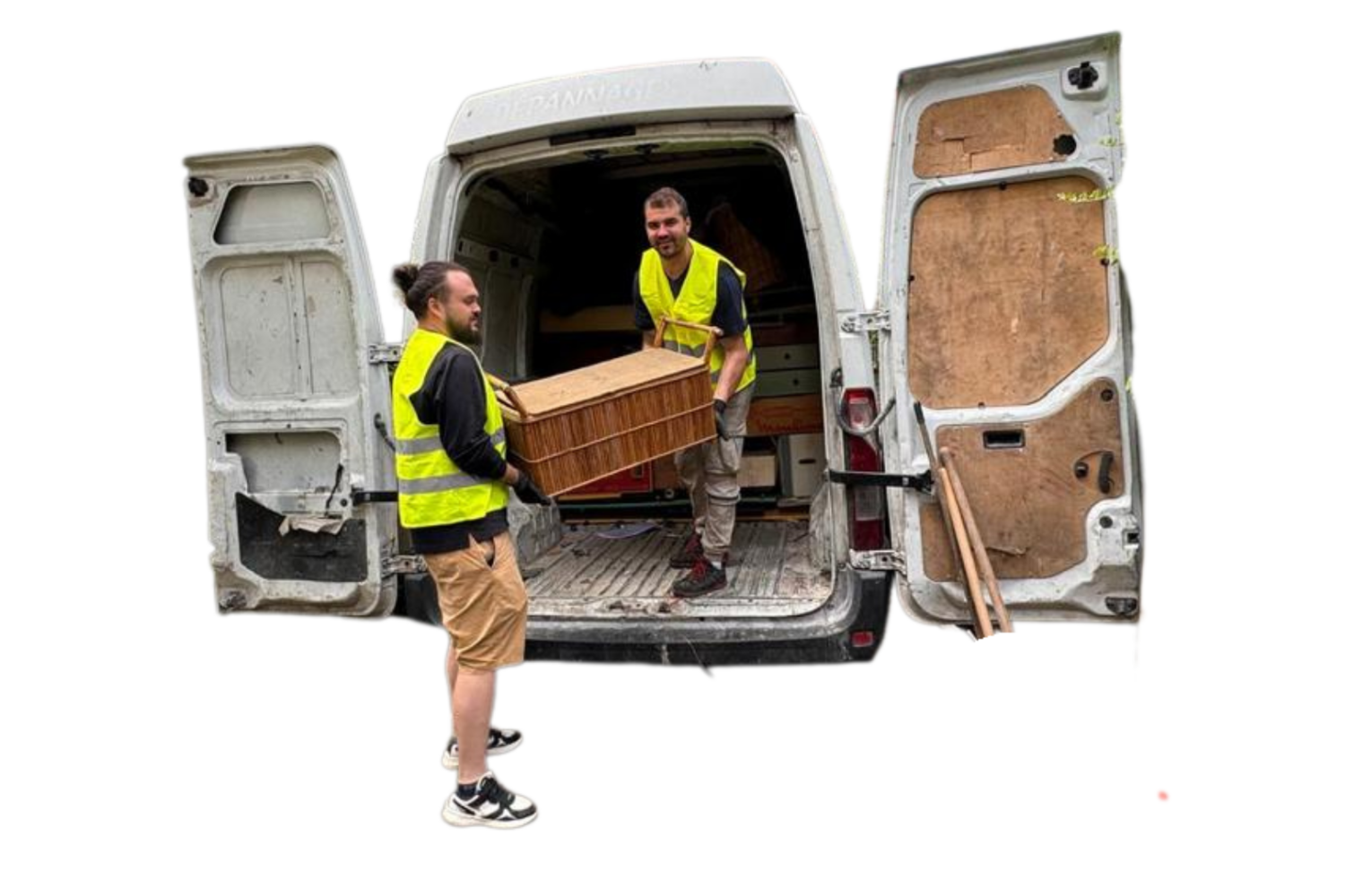 Deux employés de DND Services effectuent le chargement d'un meuble en osier dans un camion de débarras, portant des gilets jaunes de sécurité.